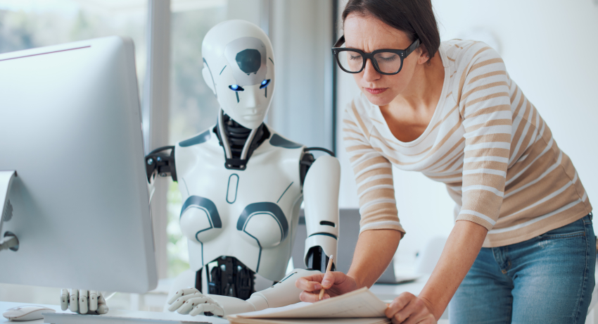 Roboter und Mensch am Bürotisch gemeinsam 