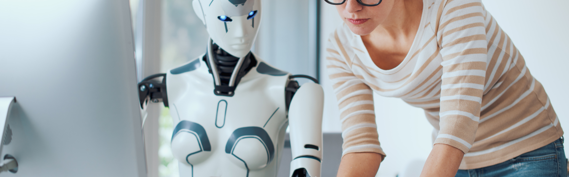 Roboter und Mensch am Bürotisch gemeinsam